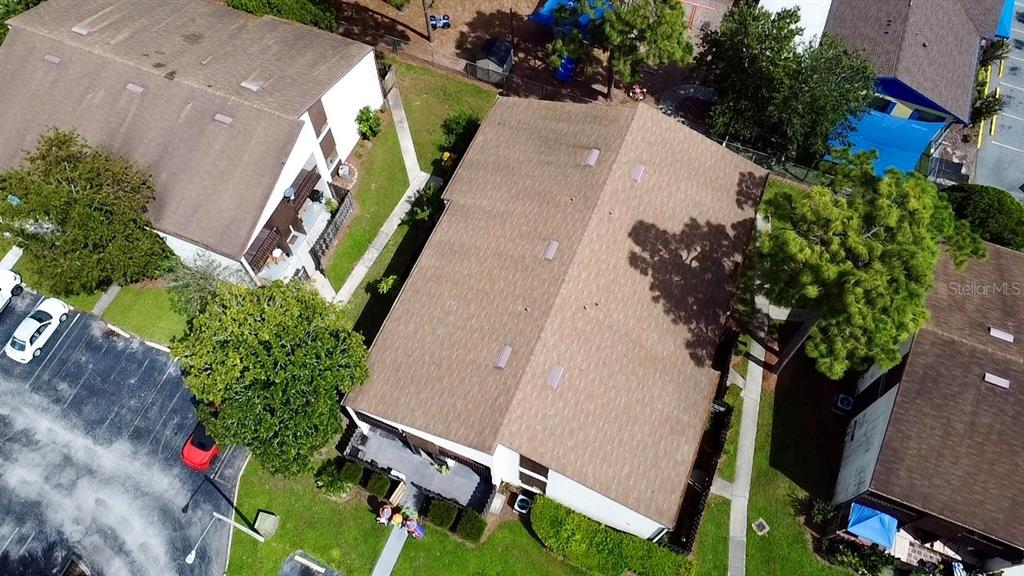 an aerial view of a house with a yard and potted plants