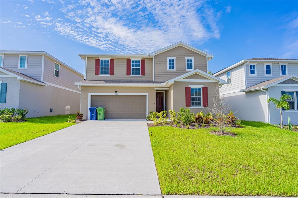 a front view of a house with a yard and garage