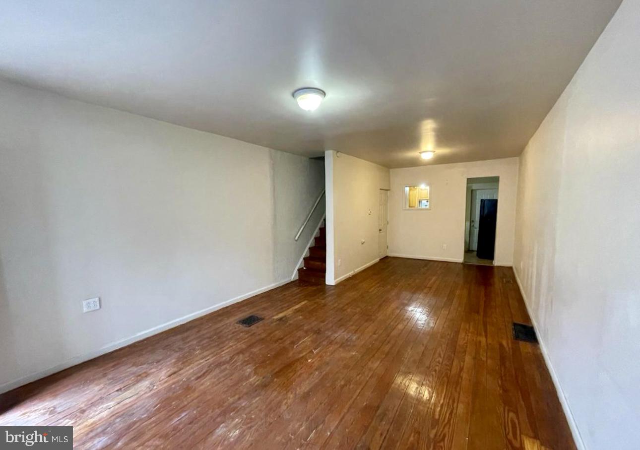 a view of empty room with wooden floor