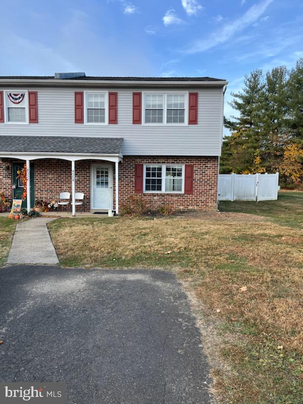 a front view of brick house with a yard