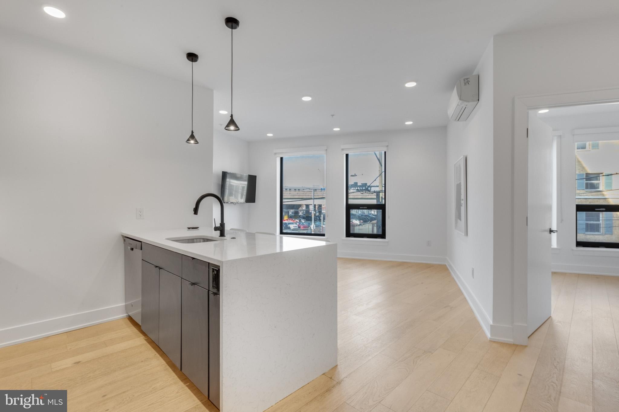 a view of a kitchen with a sink wooden floor and a chandelier