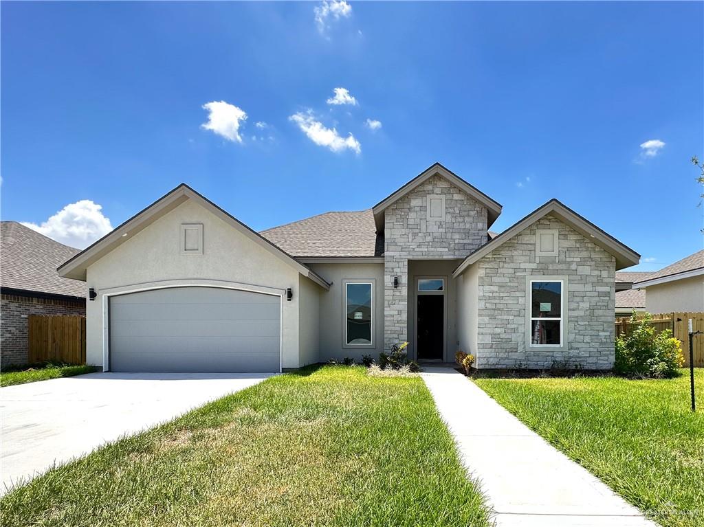 View of front of house featuring a front yard and a garage