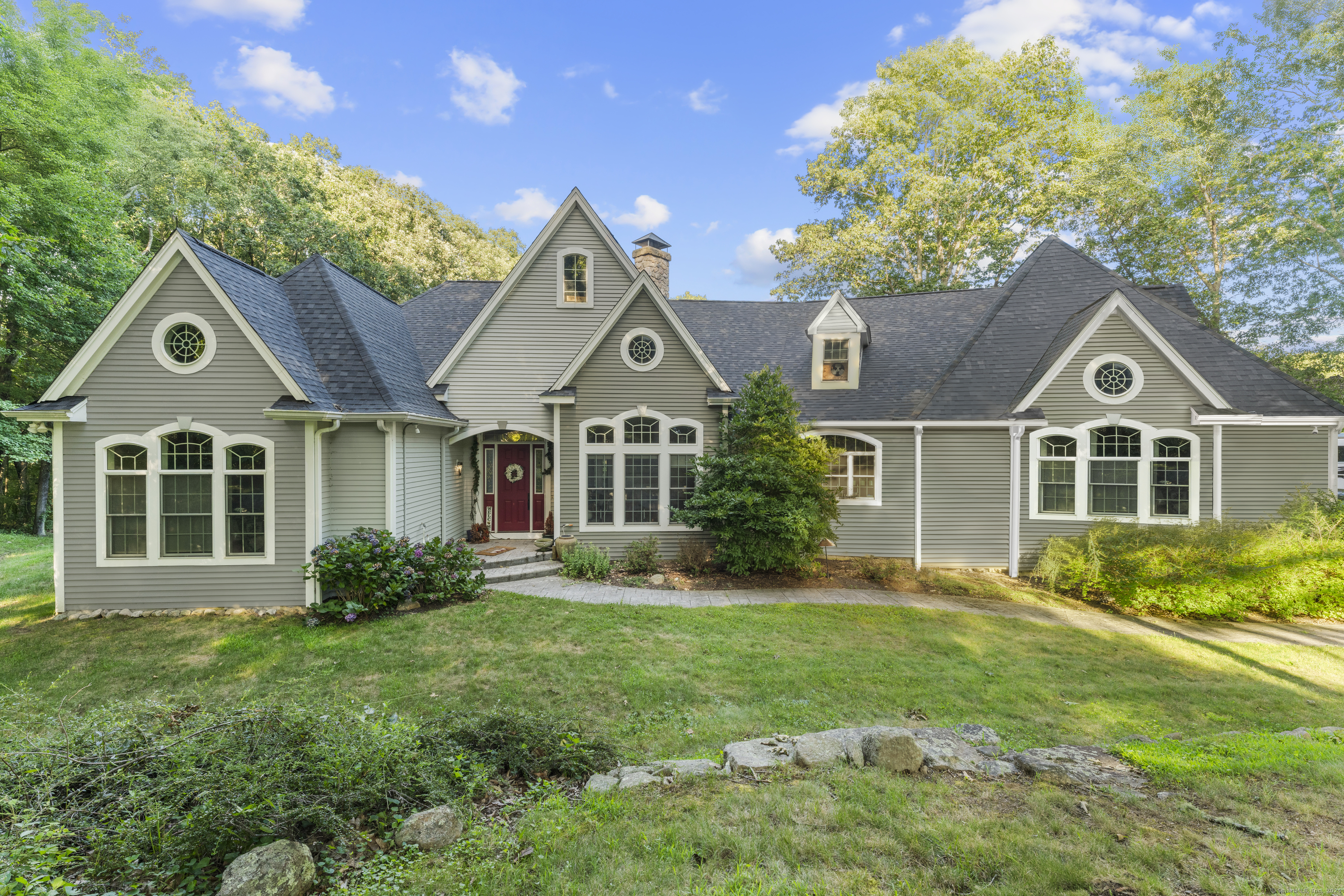 a front view of a house with a yard and trees