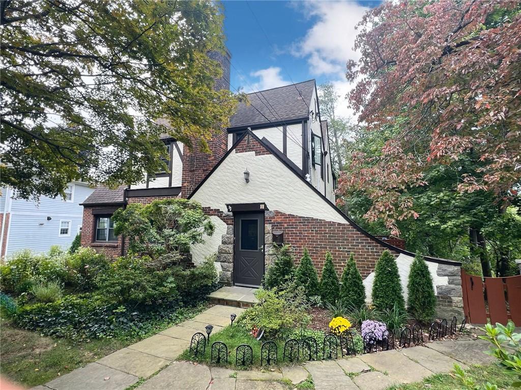 a front view of a house with a yard and potted plants