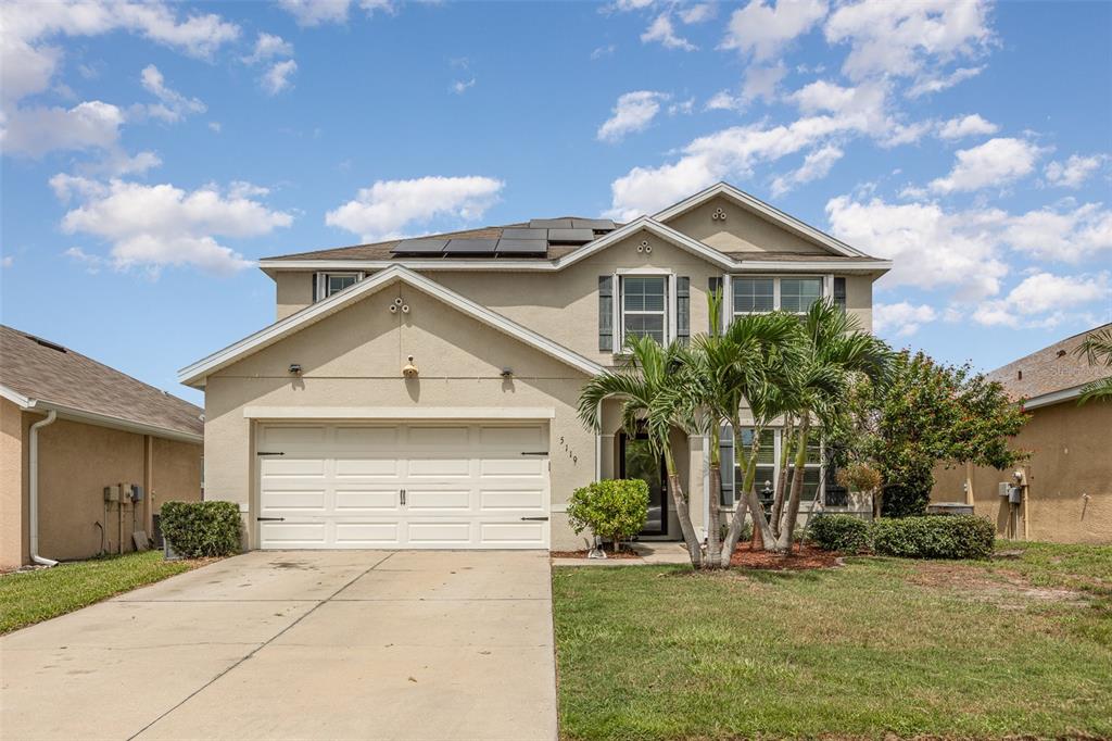 a front view of a house with a yard and garage