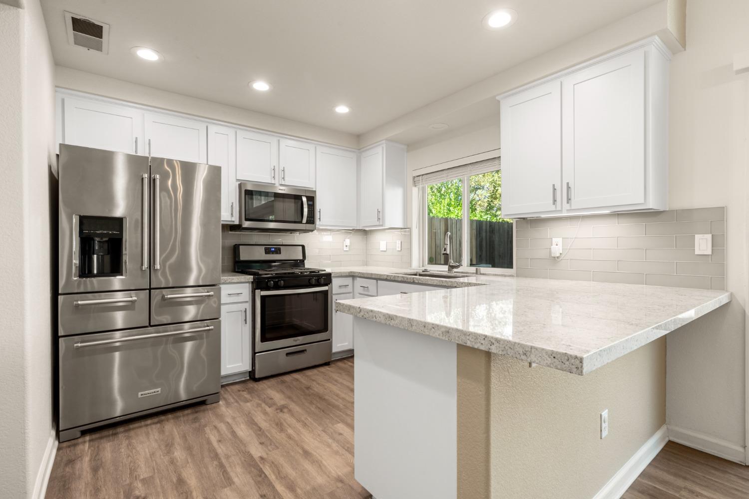 a kitchen with appliances a sink and a window