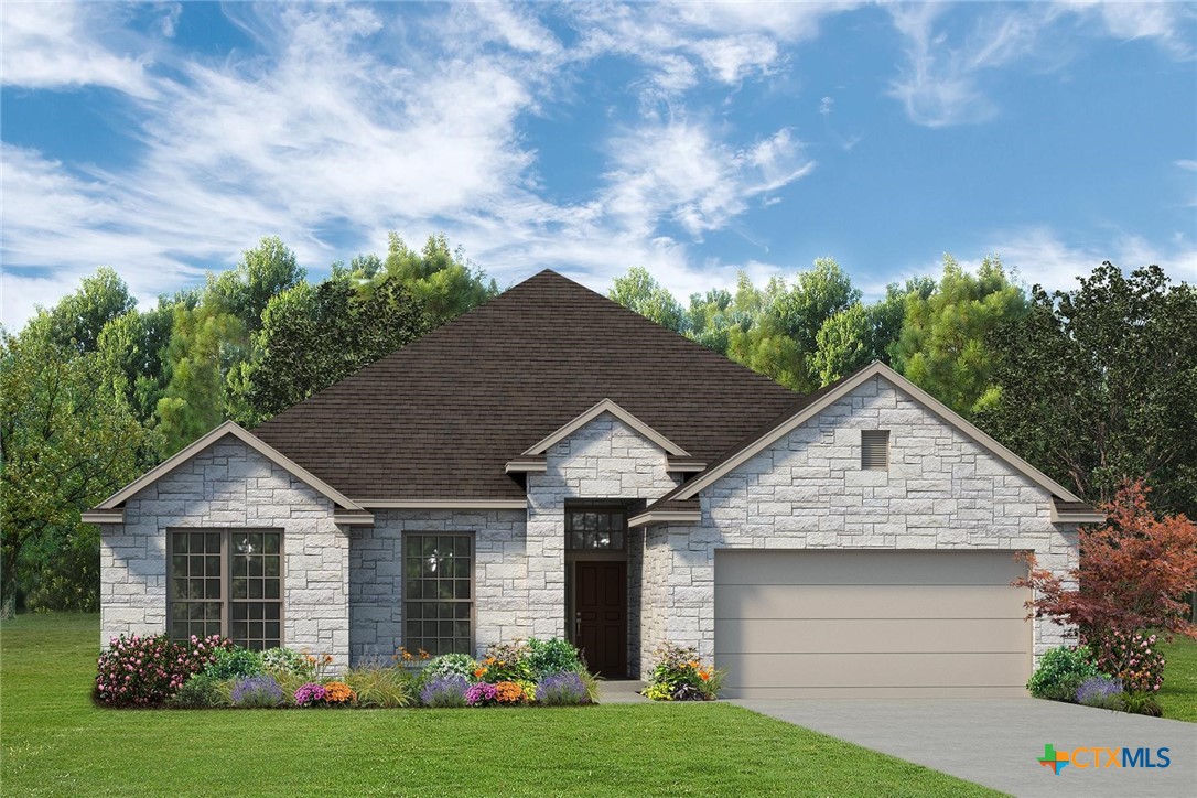 a front view of a house with a garden and yard