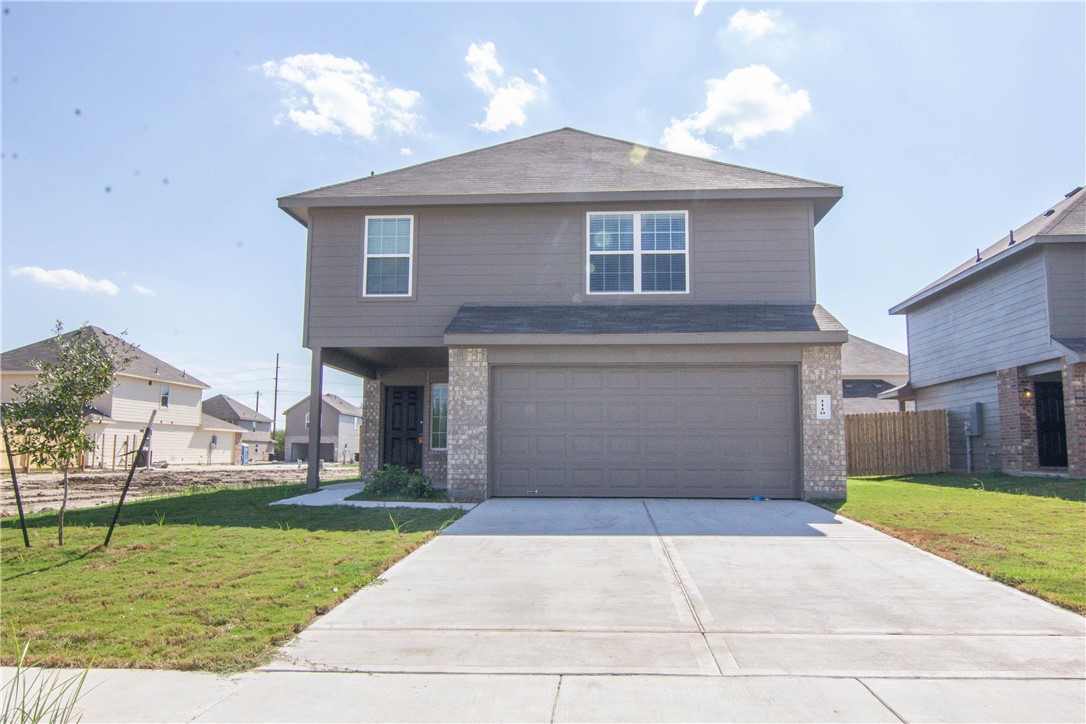 a front view of a house with a yard and garage