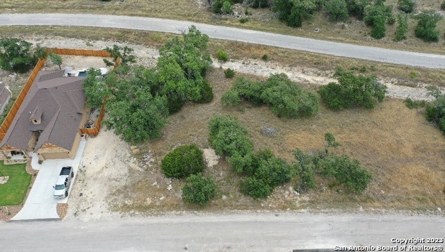 an aerial view of a house with a yard and greenery