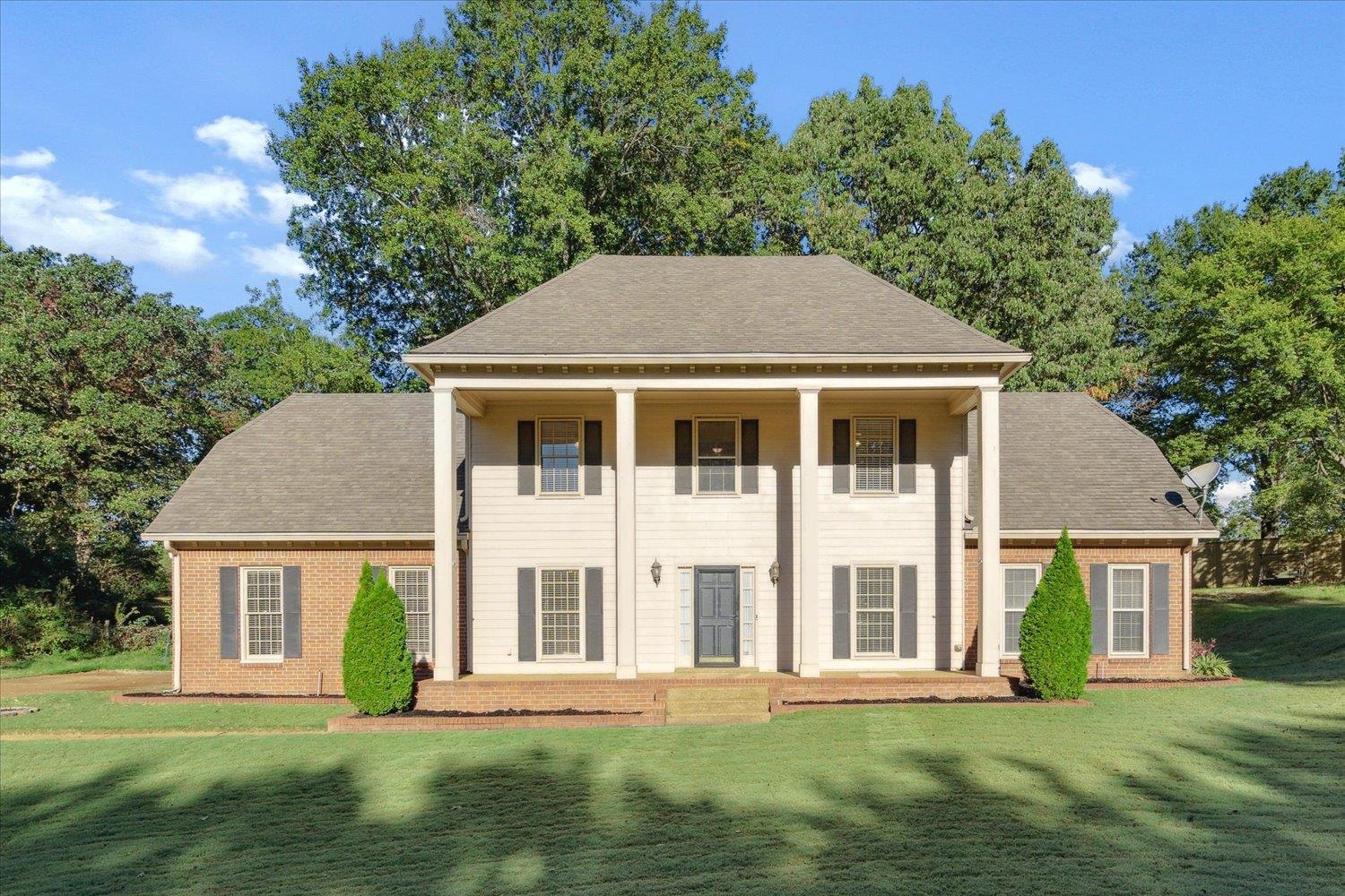 a front view of a house with a garden