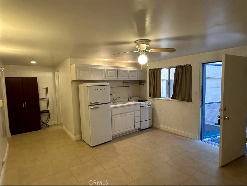 a view of a kitchen with refrigerator and a ceiling fan