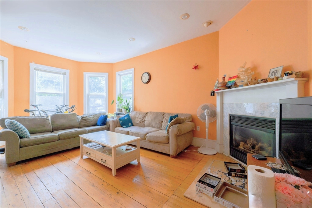 a living room with furniture flat screen tv and a large window