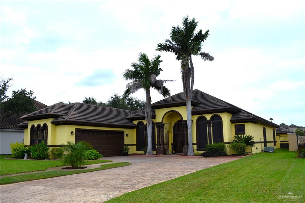 Mediterranean / spanish-style home featuring a garage and a front lawn