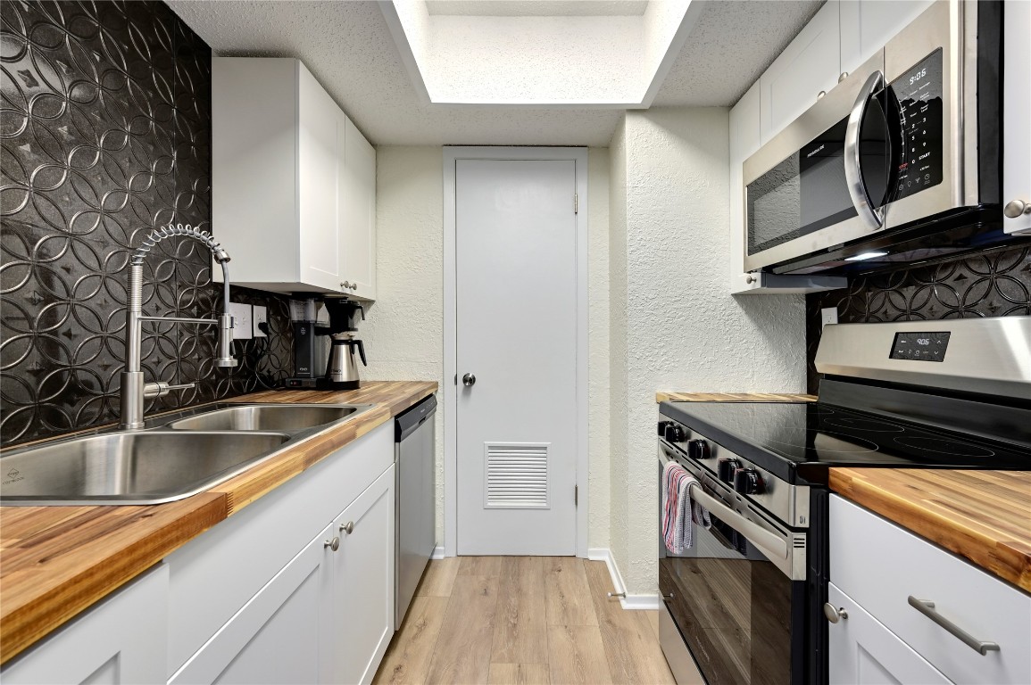 a kitchen with stainless steel appliances granite countertop a sink and a stove