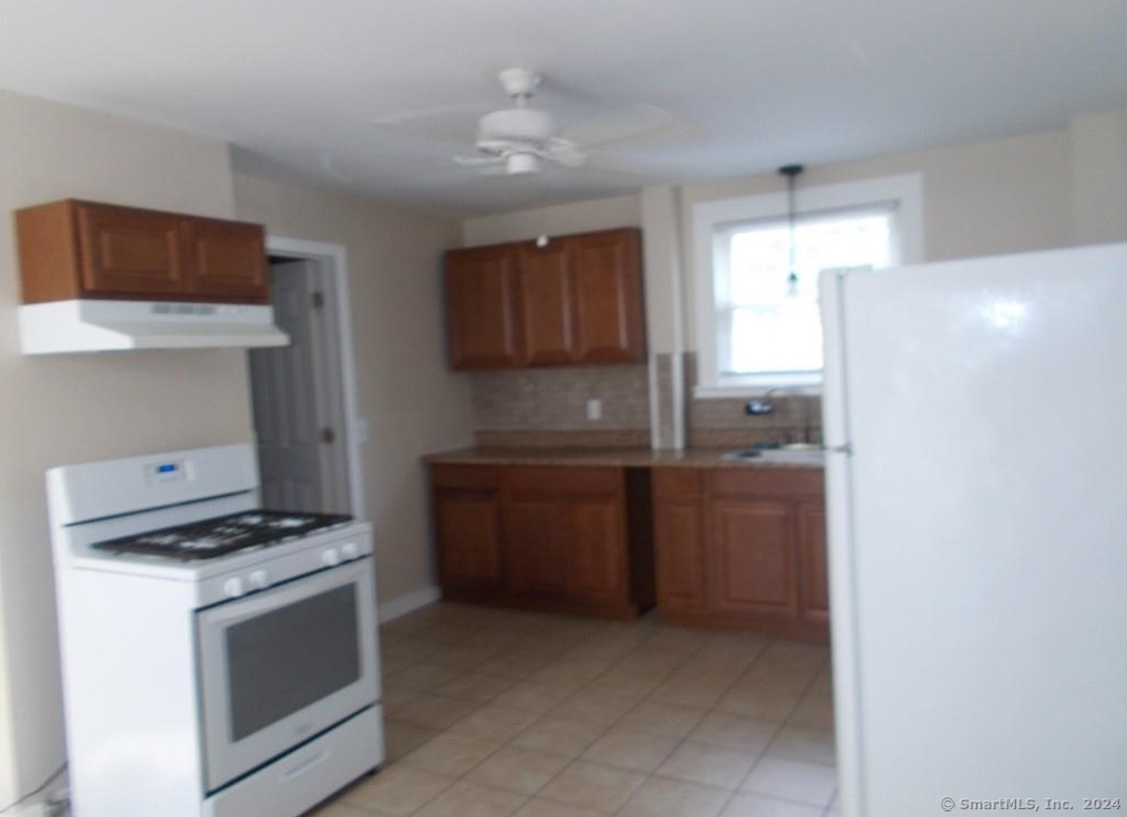 a kitchen with granite countertop a refrigerator and a stove