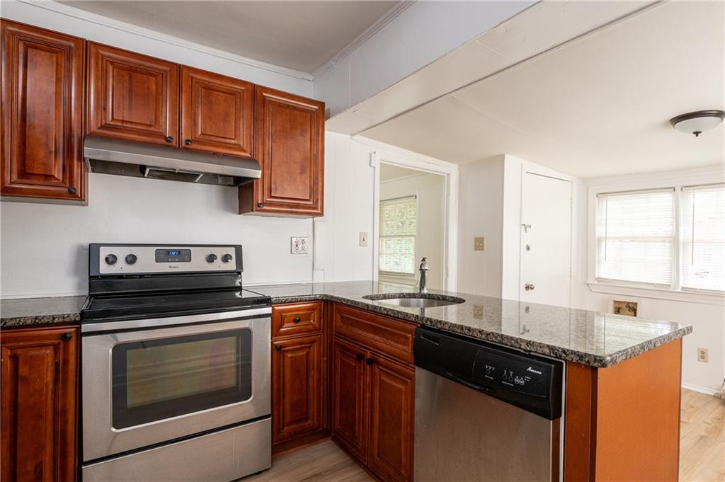 a kitchen with granite countertop a sink stove and cabinets