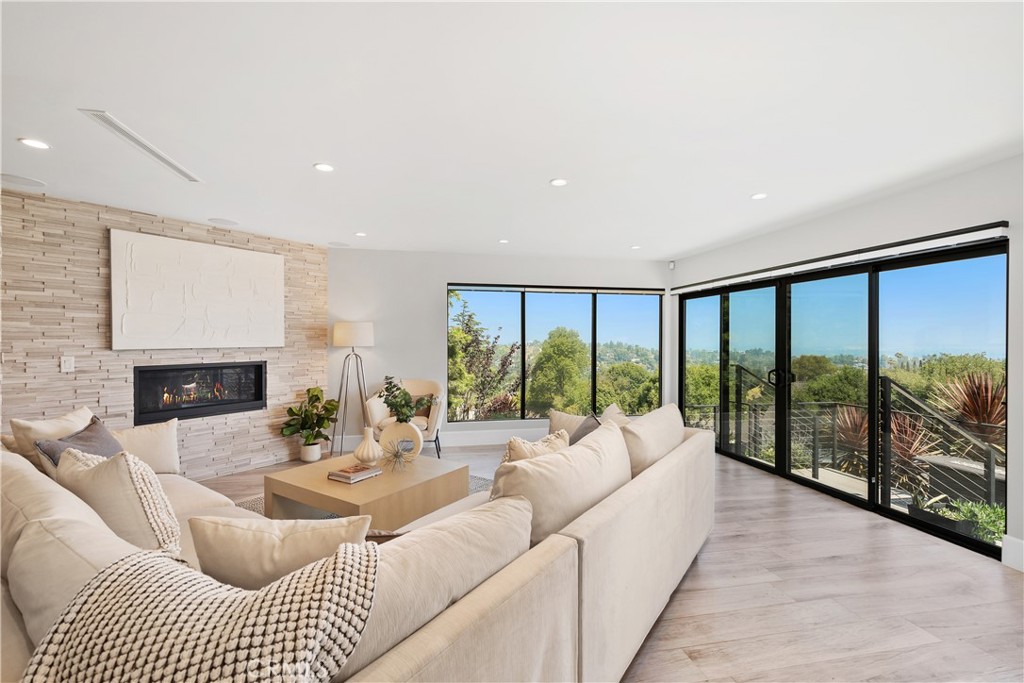 a living room with furniture large windows and a fireplace