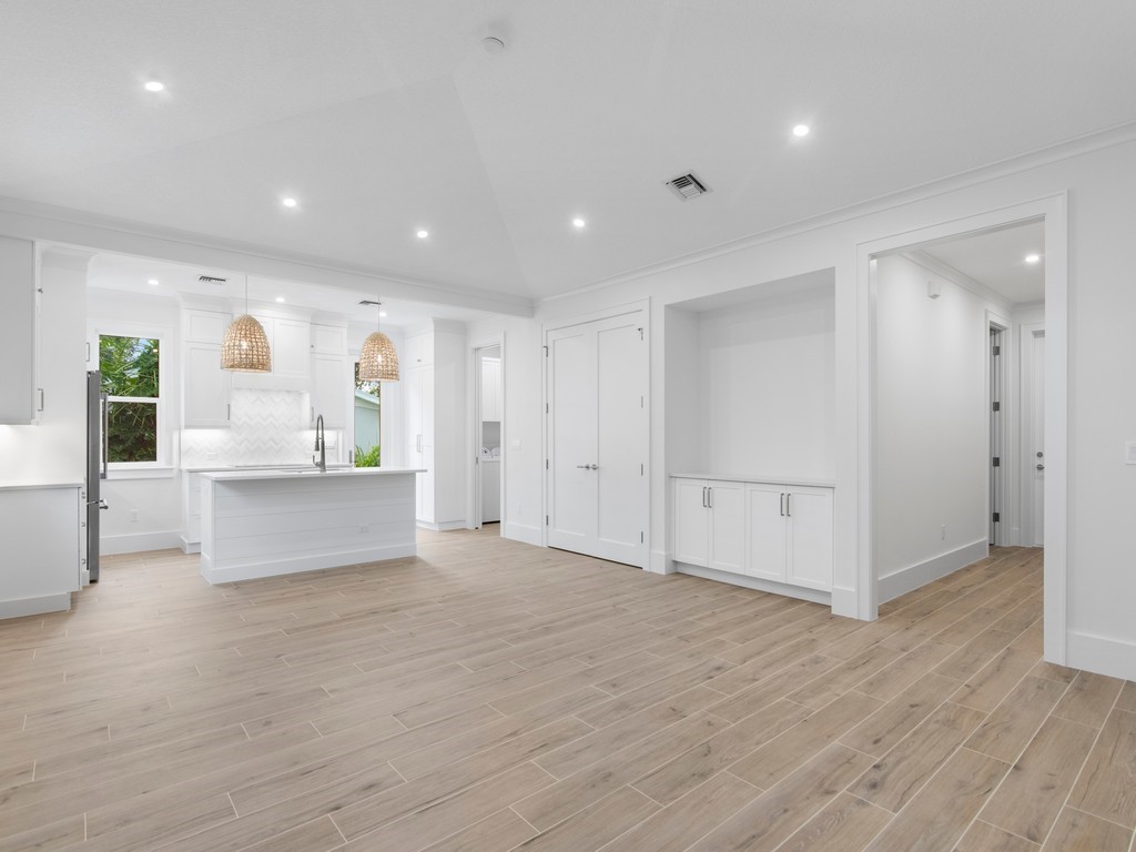 a view of kitchen with white cabinets and wooden floor