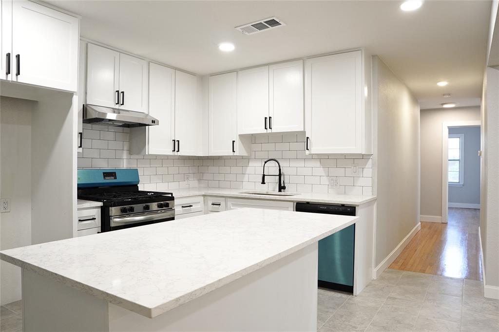 a kitchen with stainless steel appliances a stove a sink a refrigerator and cabinets