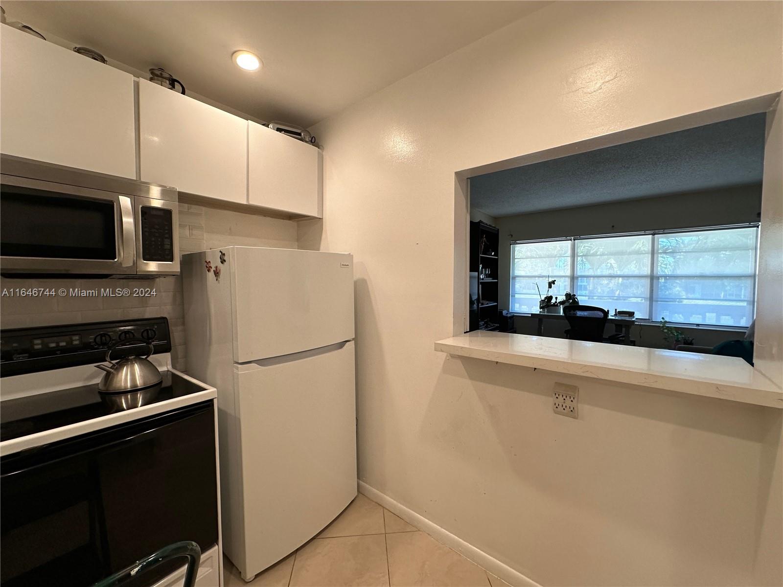 a kitchen with a refrigerator a stove and a sink