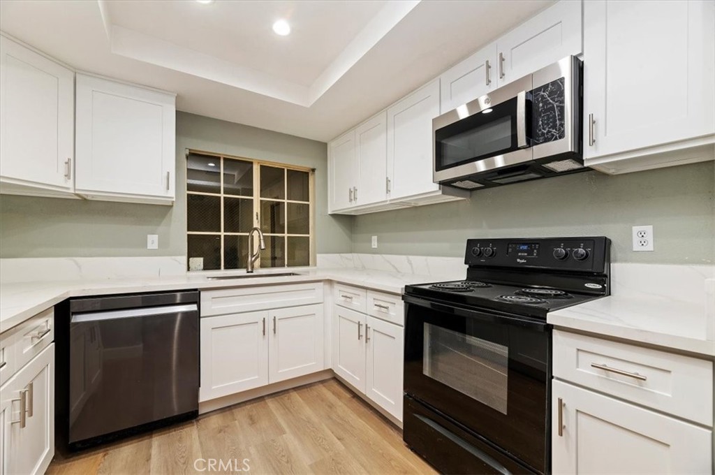 a kitchen with cabinets stainless steel appliances and a sink