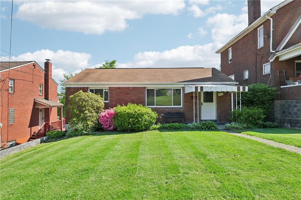 a front view of a house with a garden and plants