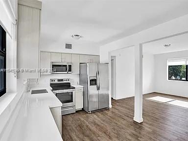 a kitchen with stainless steel appliances a stove a microwave and white cabinets