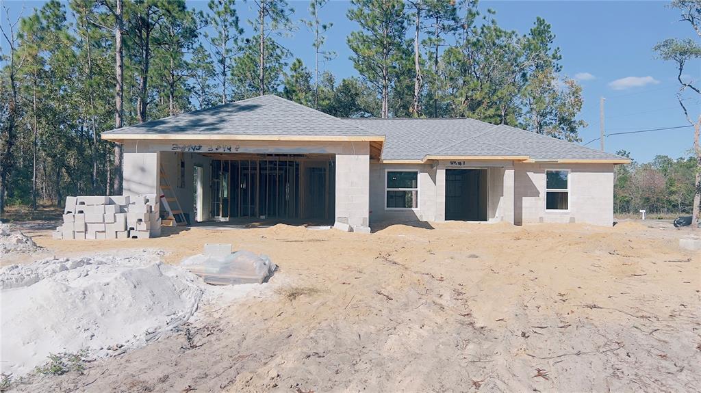 a front view of a house with a yard covered with trees