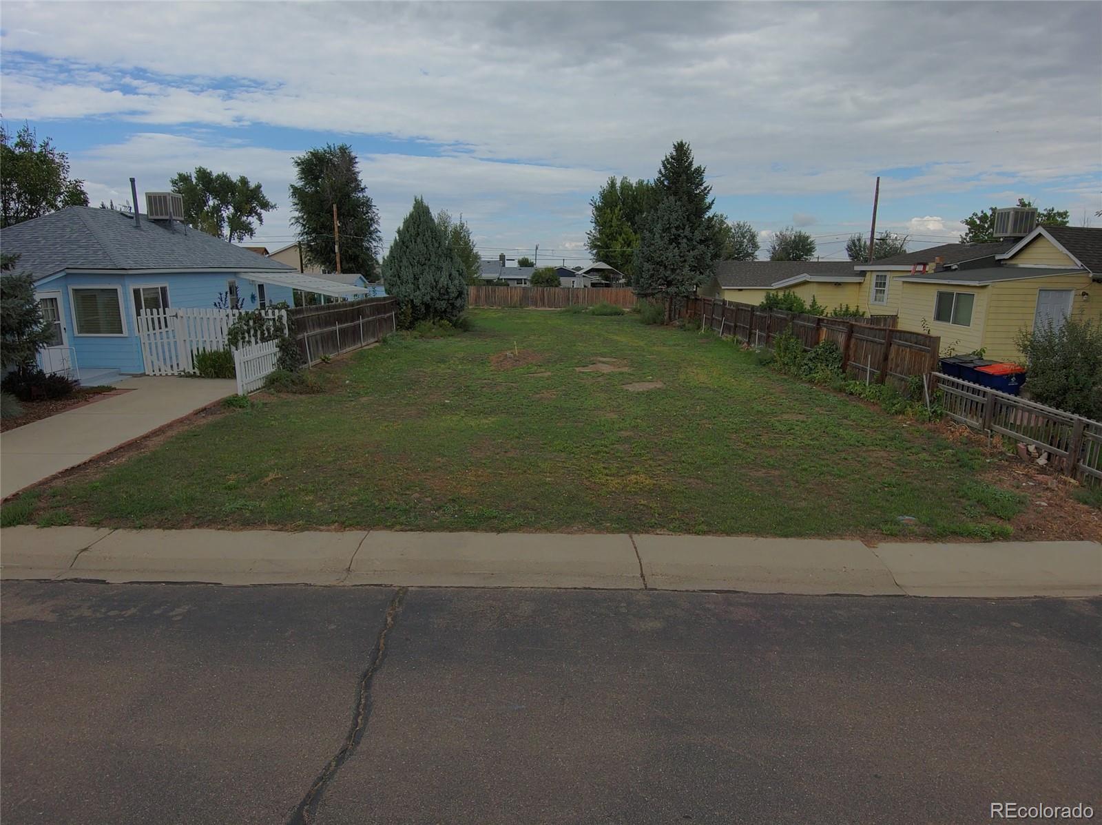 a view of a house with a yard and a street