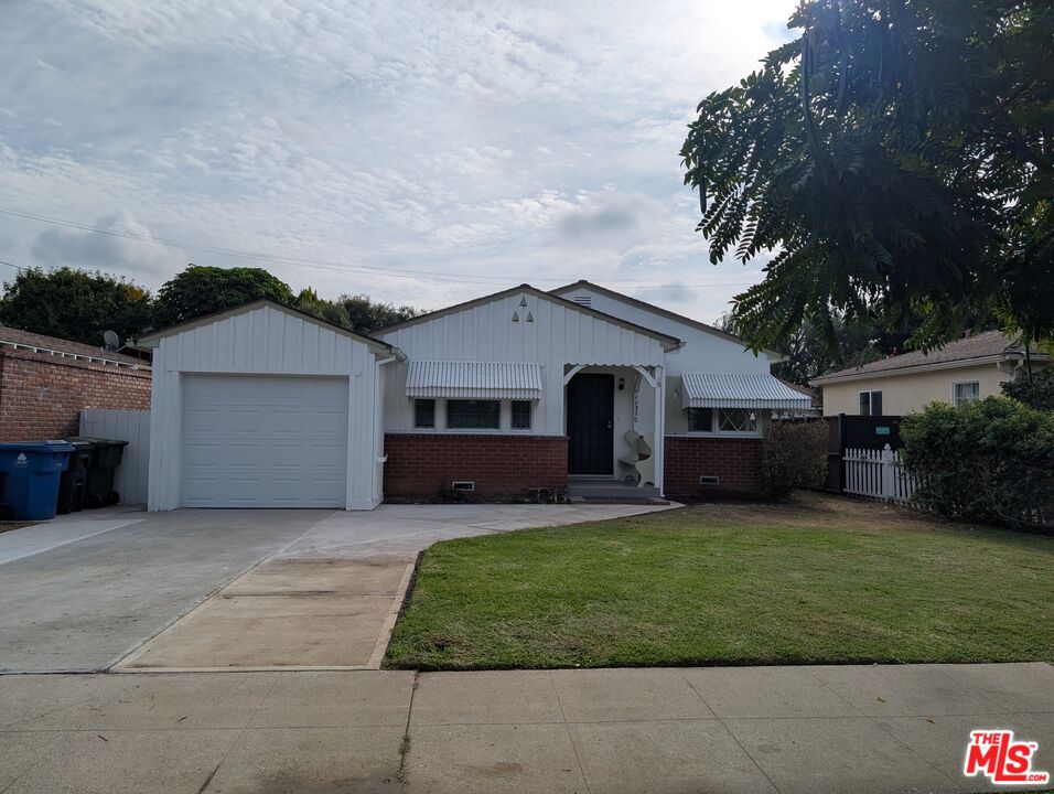 a front view of a house with a garden and yard