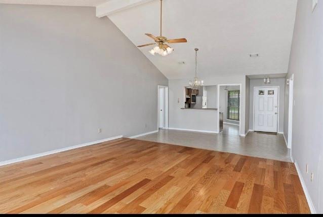 a view of a livingroom with wooden floor and kitchen space