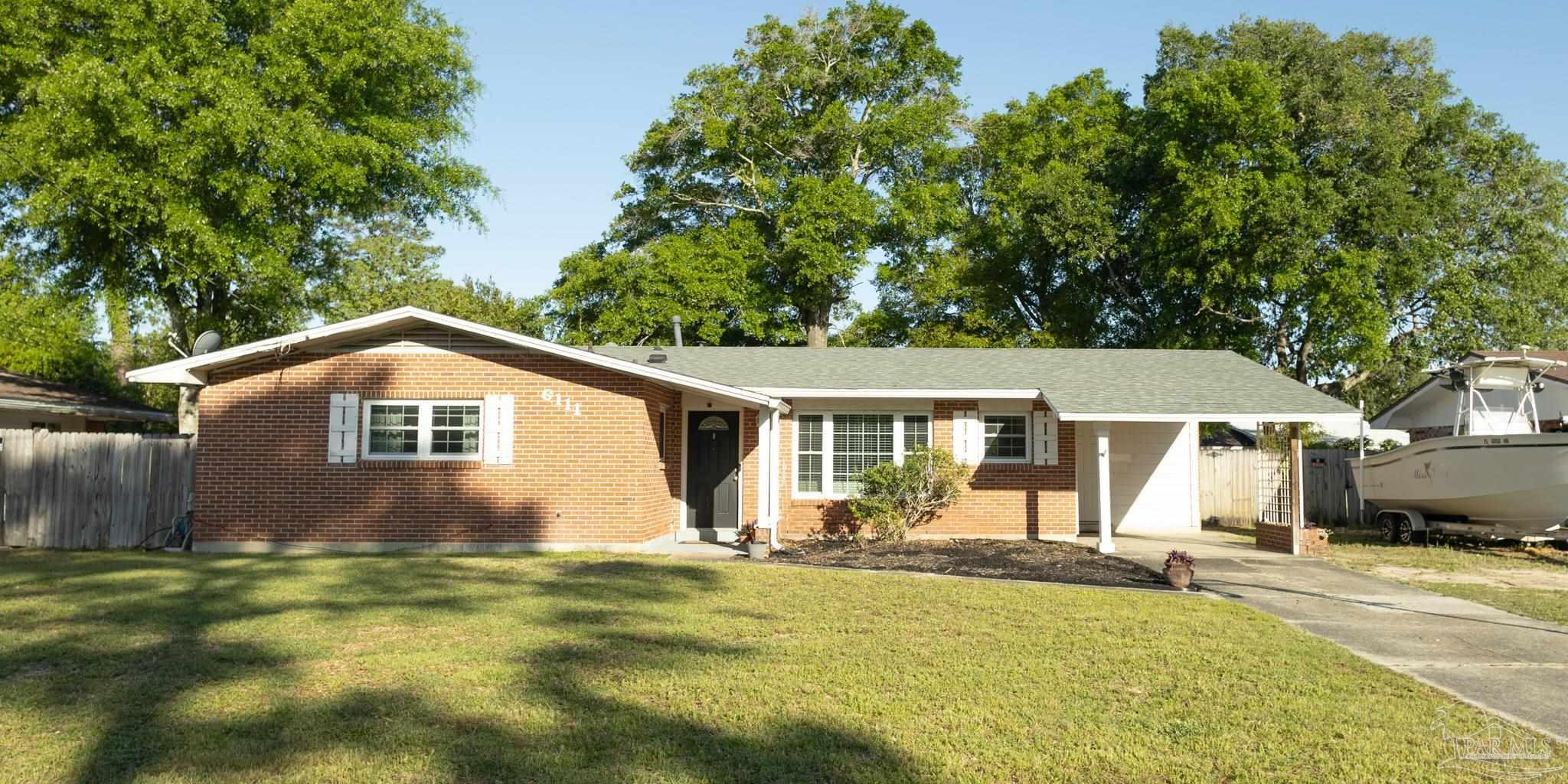 a front view of a house with a yard and trees