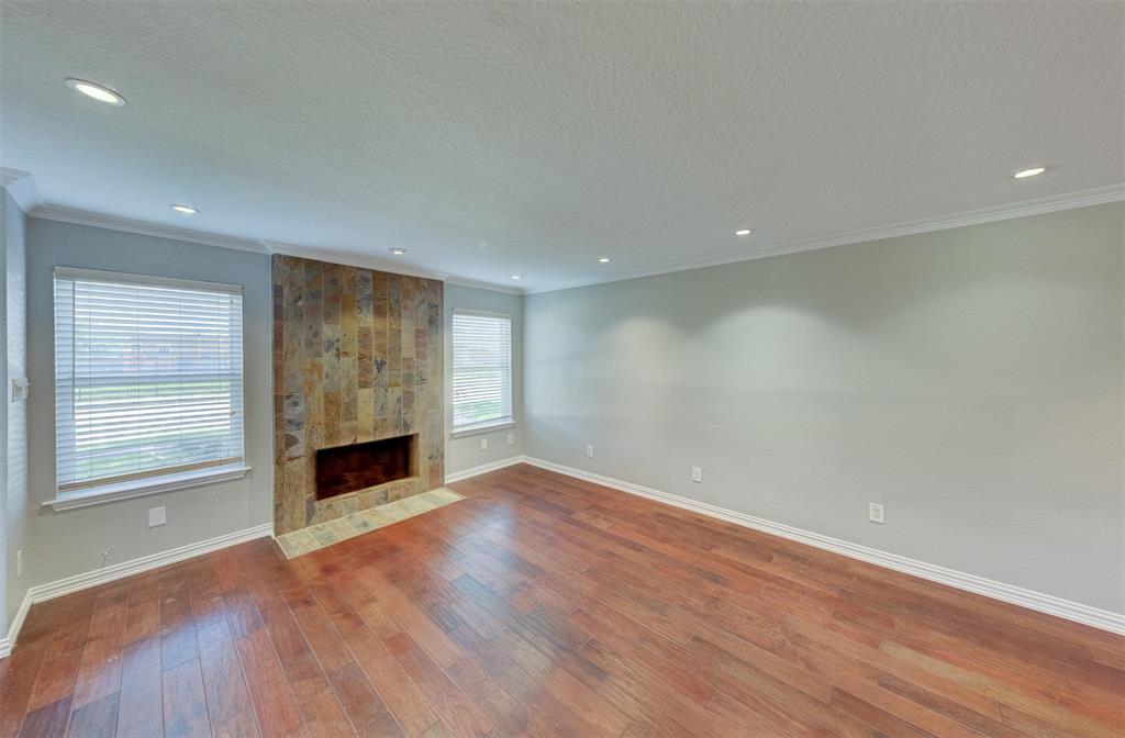 a view of empty room with wooden floor and fireplace