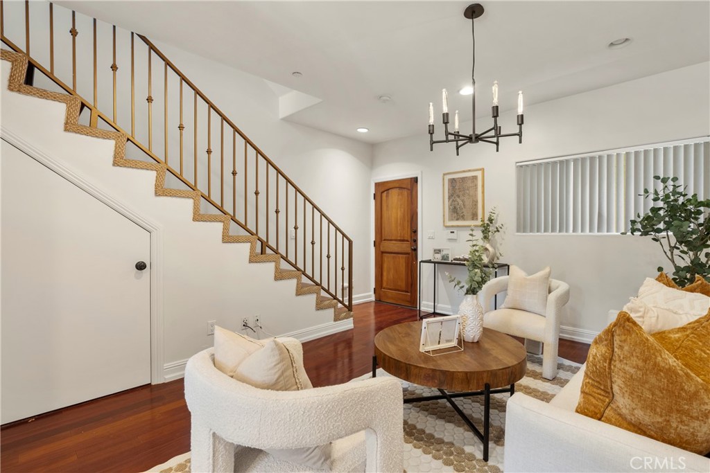 a view of a livingroom with furniture stairs and a chandelier