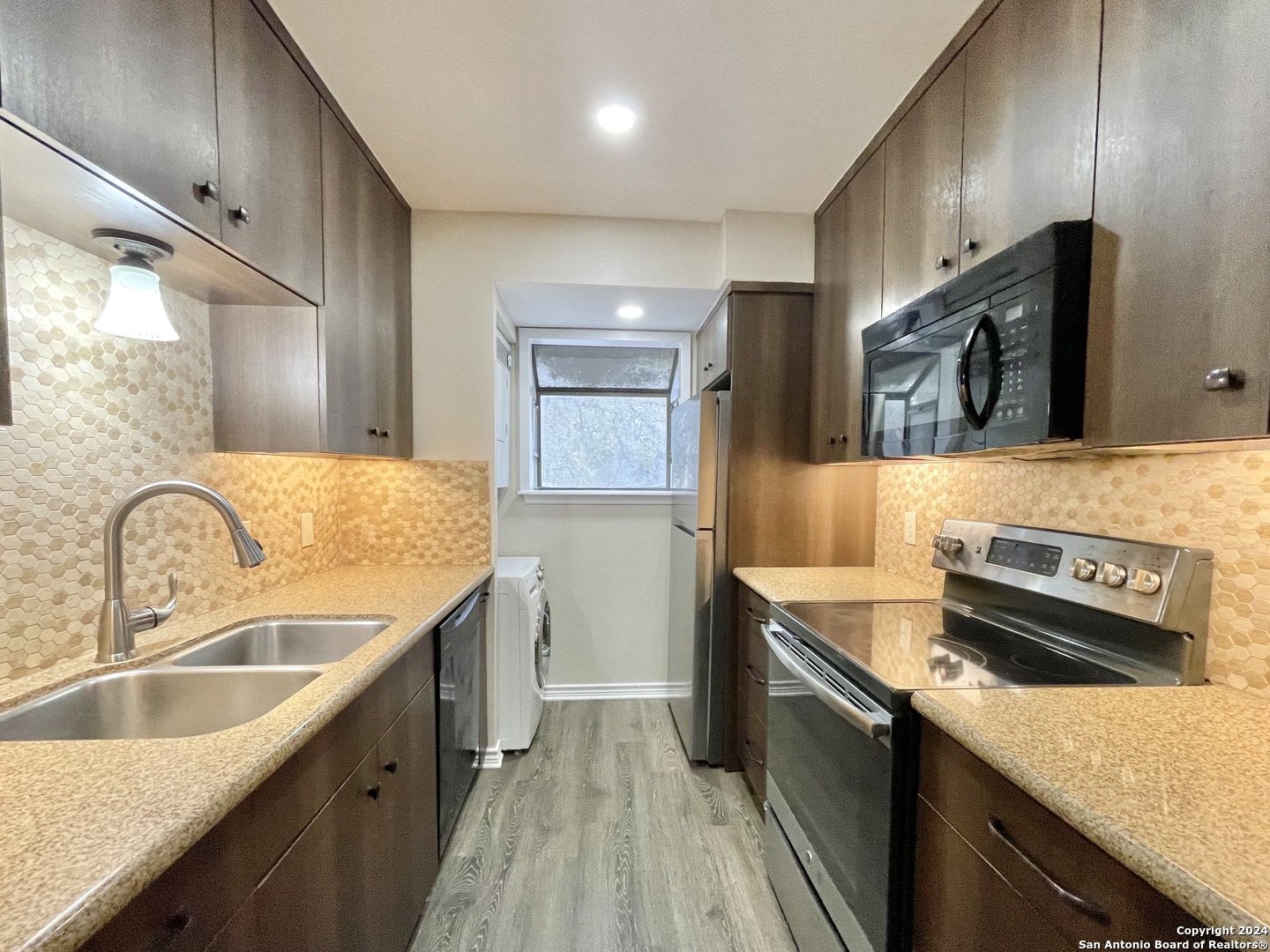 a kitchen with stainless steel appliances granite countertop a sink stove and refrigerator