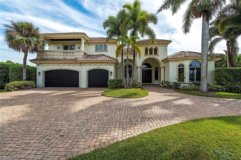 a front view of a house with a garden and palm trees