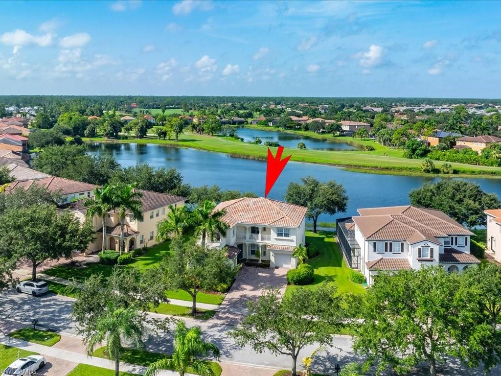 an aerial view of a house with a yard and lake view