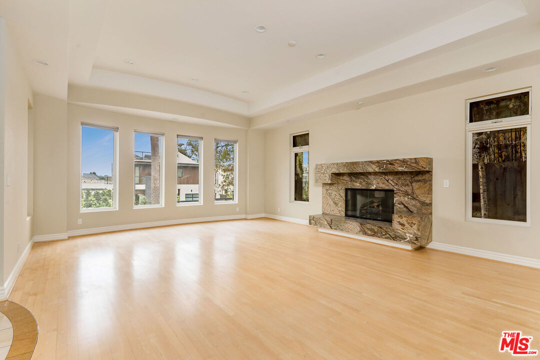 a view of an empty room with a fireplace and a window