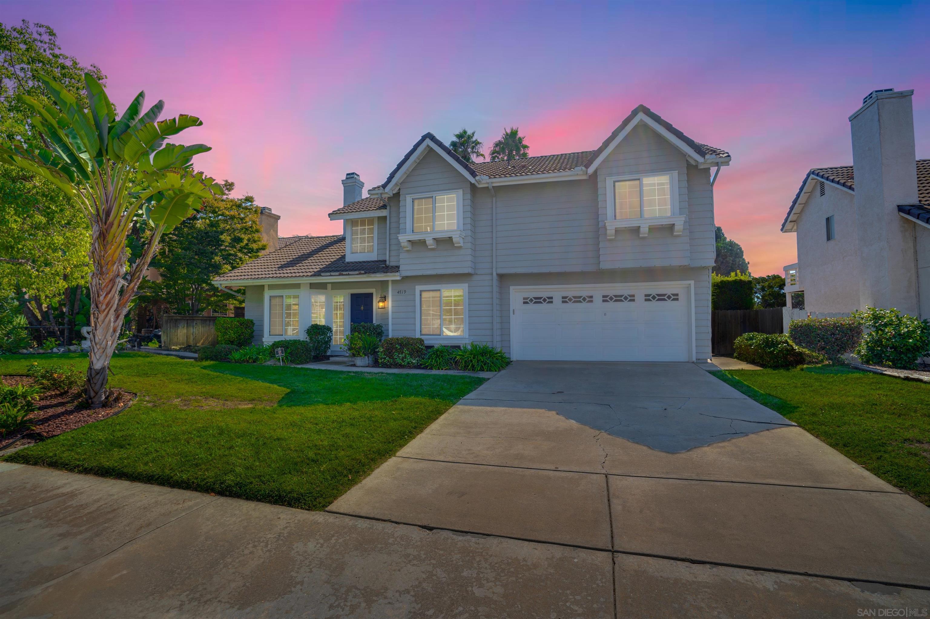 a front view of a house with a yard and a garage