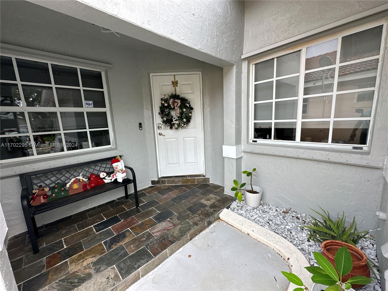 a front view of a house with a potted plant