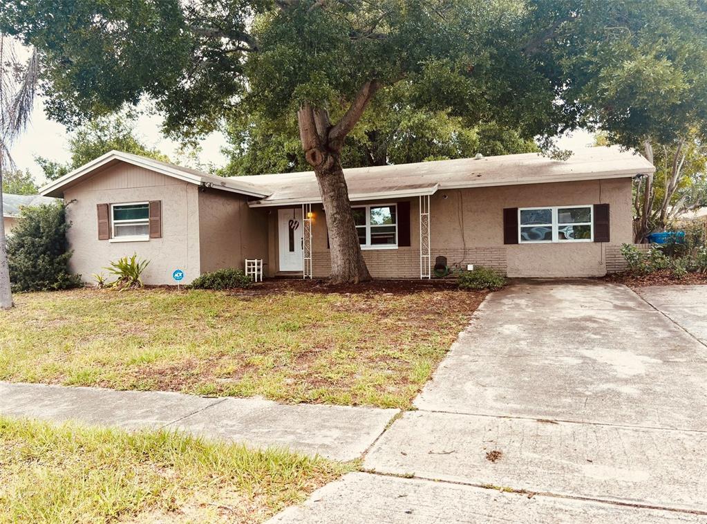 a front view of house with yard and trees around