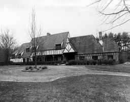 a view of a house with cars parked on road