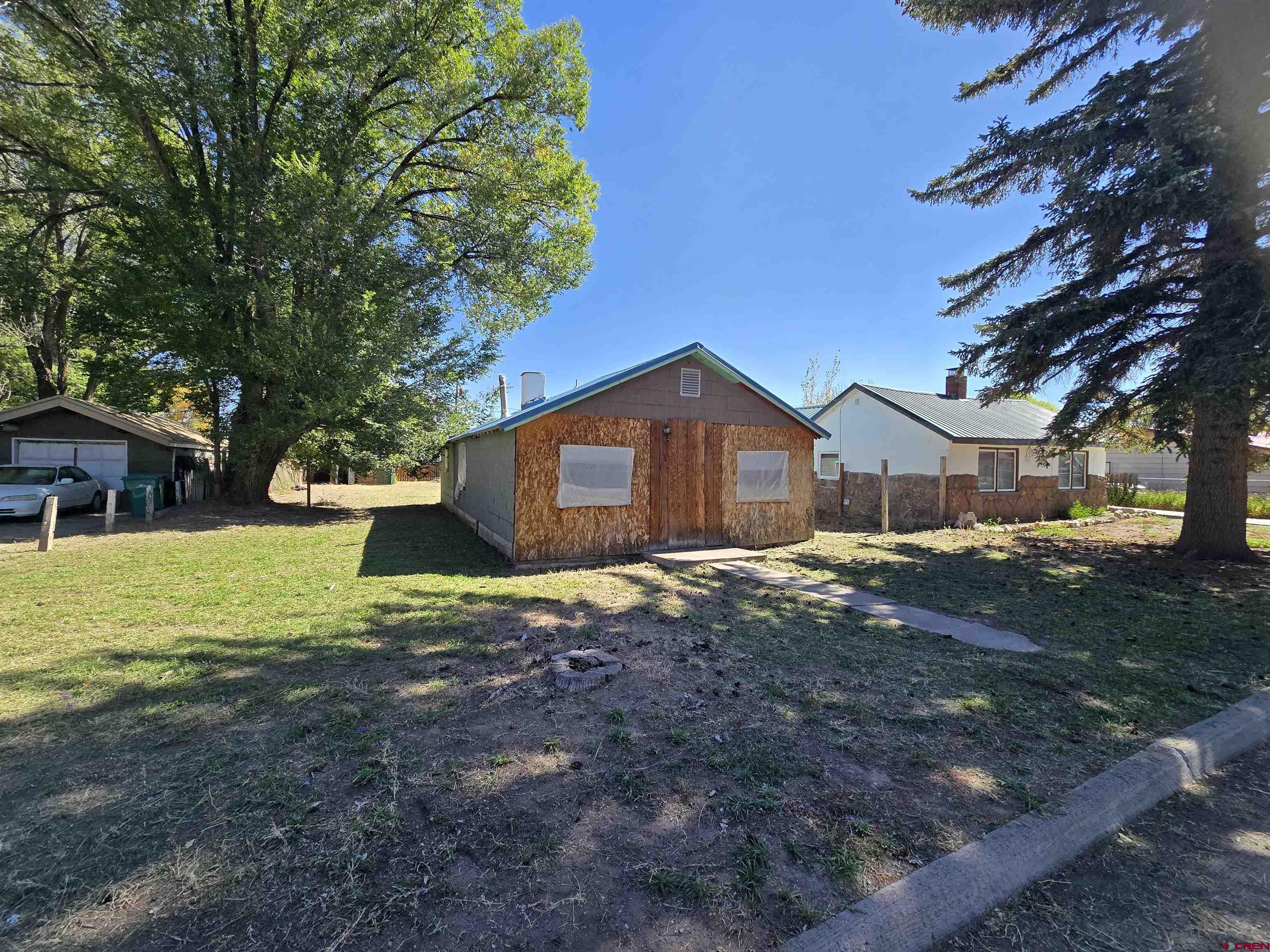 a front view of house with yard and trees in the background