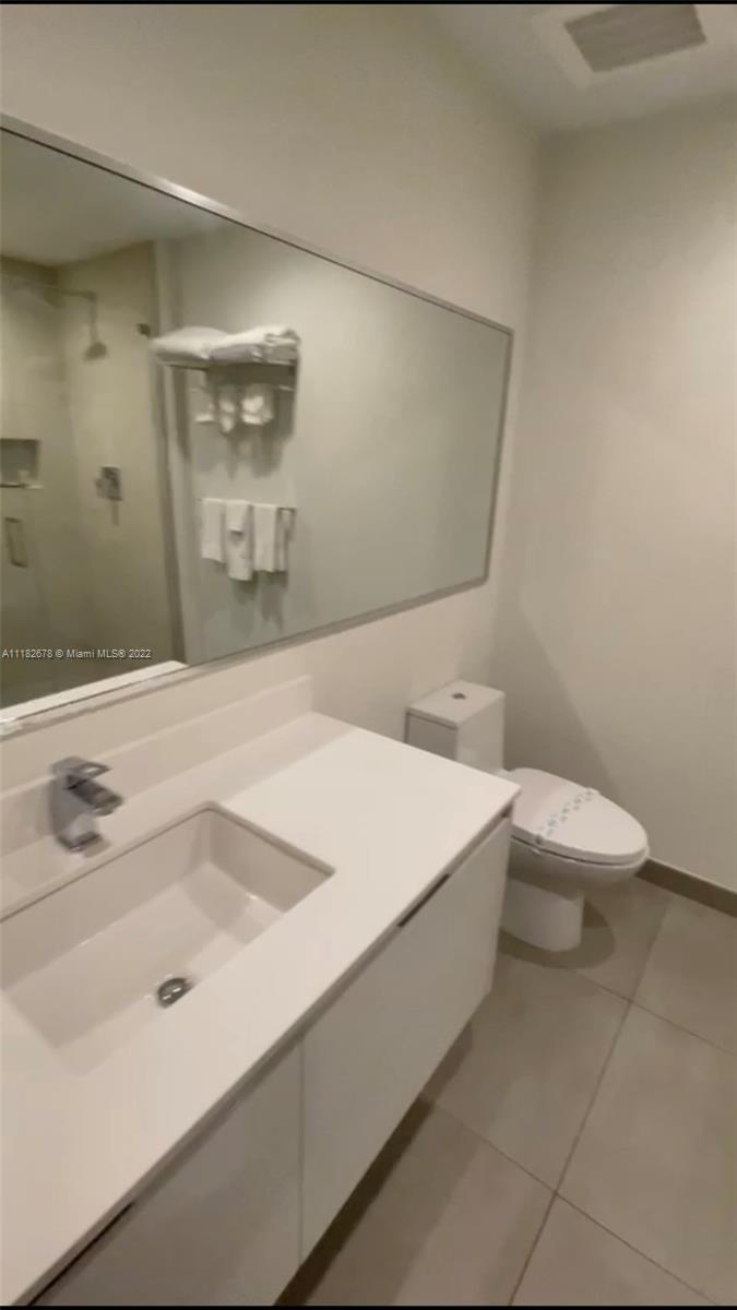 a bathroom with a sink a toilet and mirror