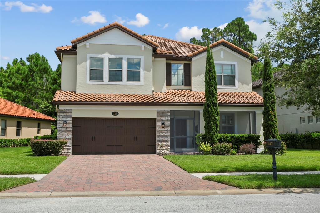 a front view of a house with a yard and garage