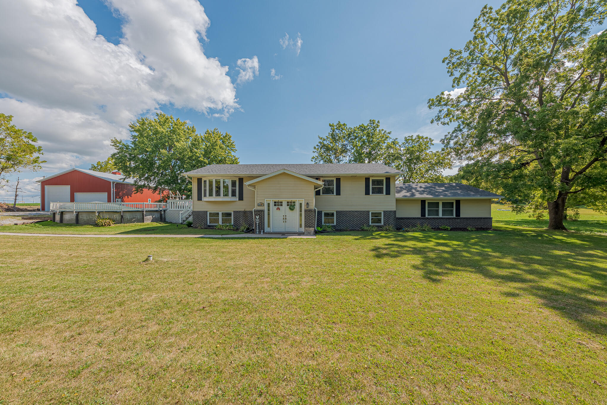 a front view of a house with a yard and swimming pool