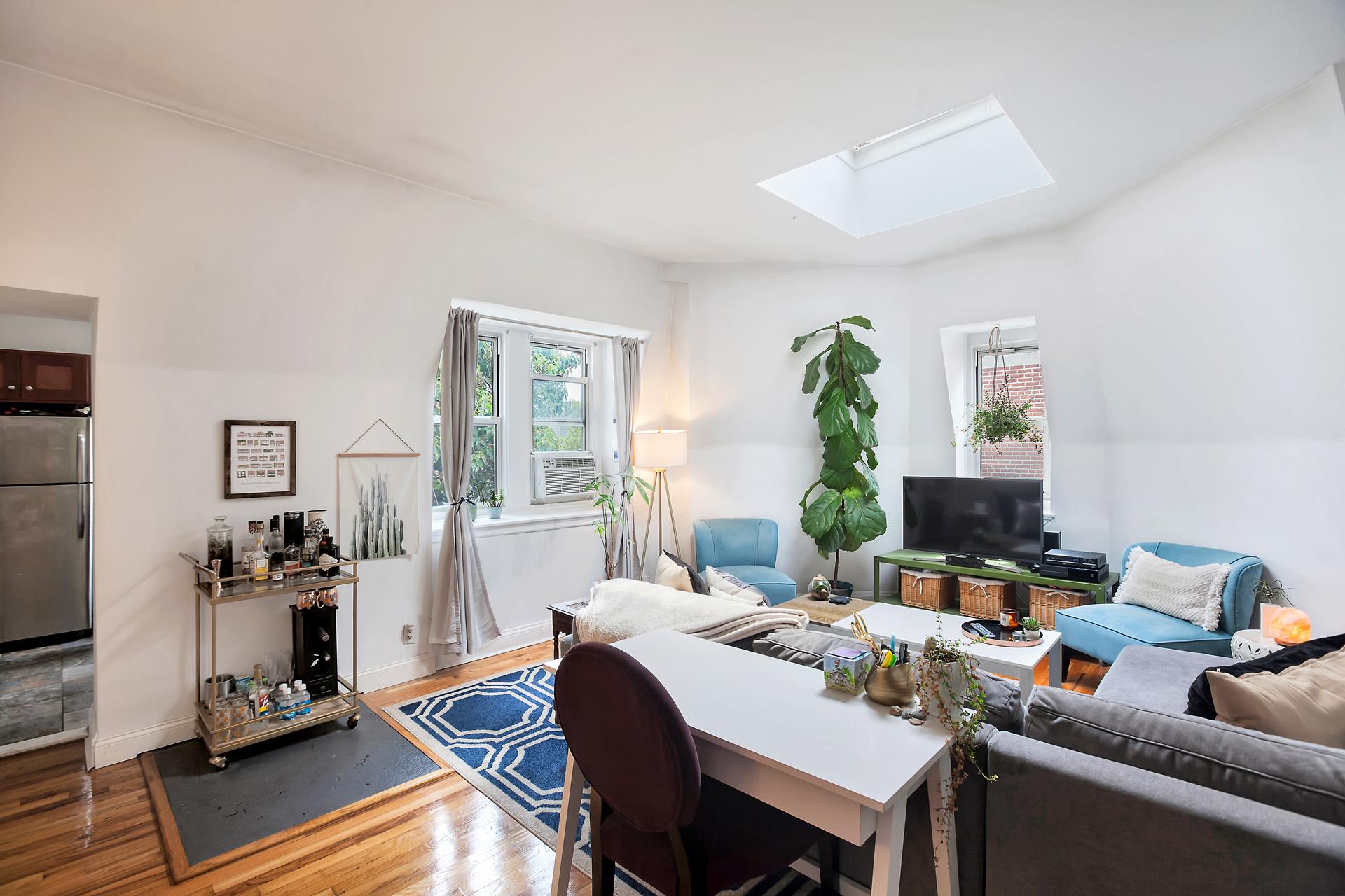 a living room with furniture a wooden floor and next to a window