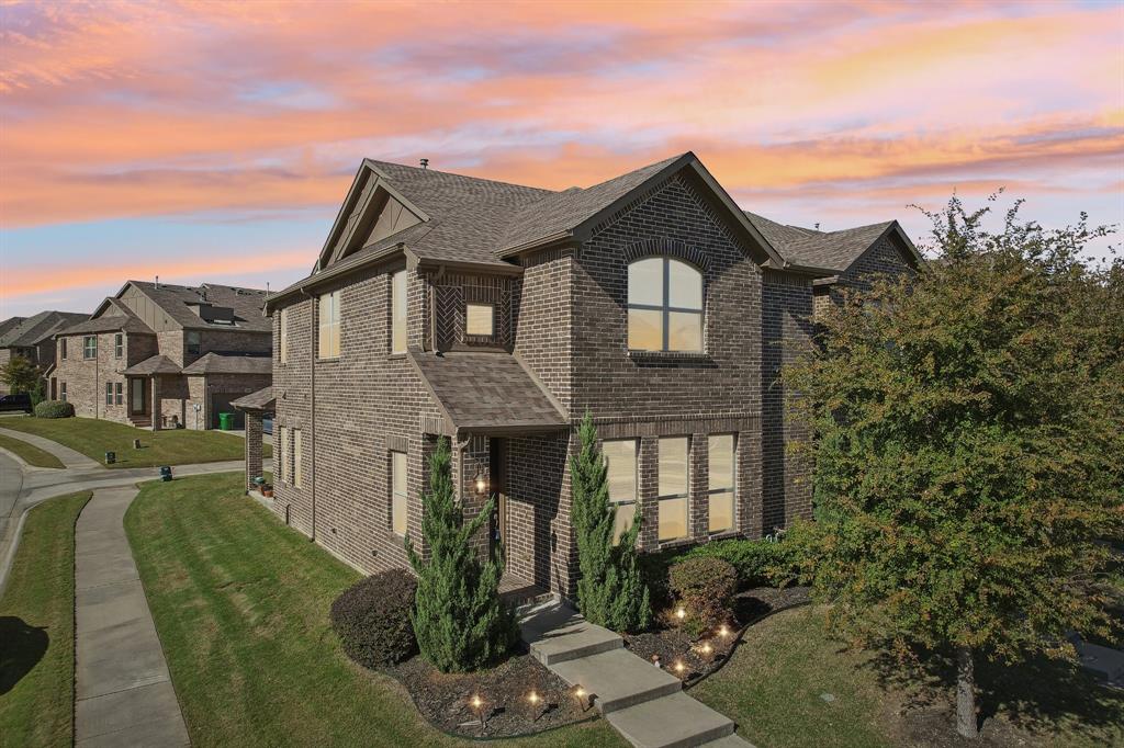 a front view of a house with a yard and mountain view in back