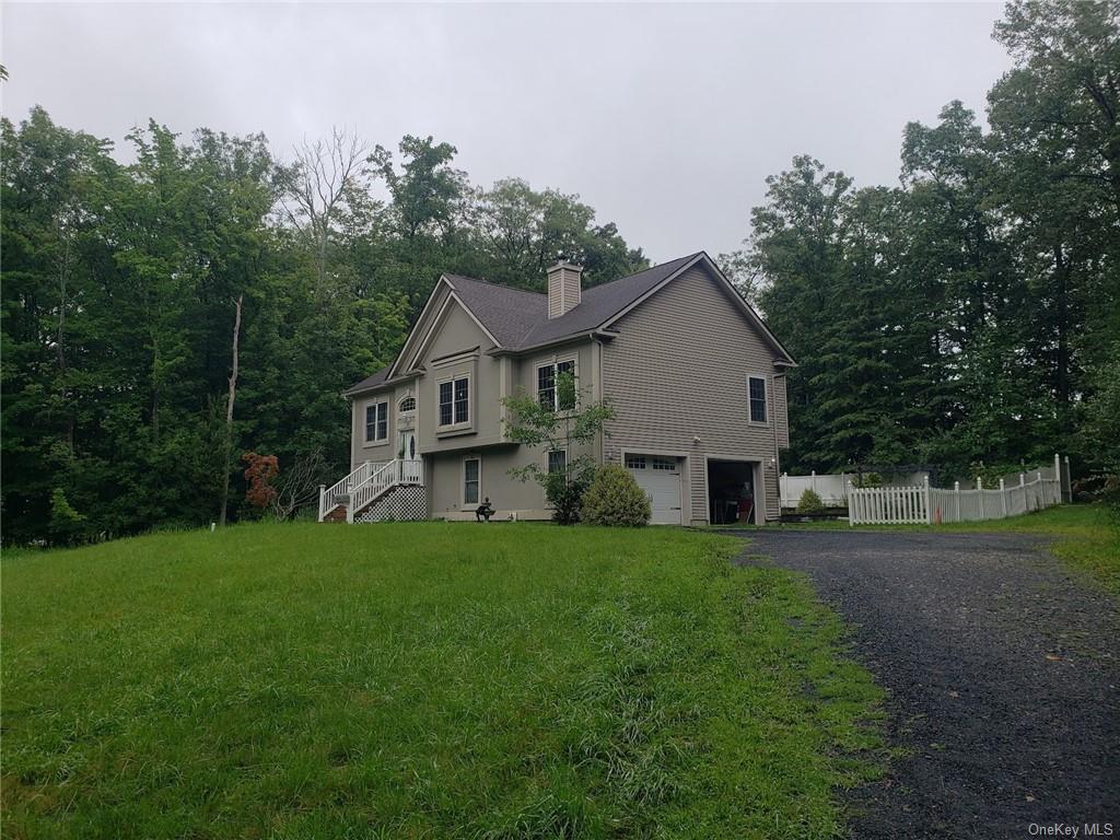 View of home's exterior featuring a yard and a garage