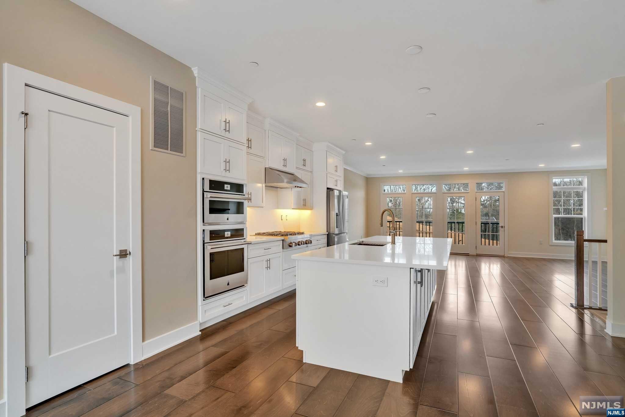 a view of a living room kitchen with furniture and wooden floor